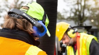 Workers wearing communication headsets for team safety.