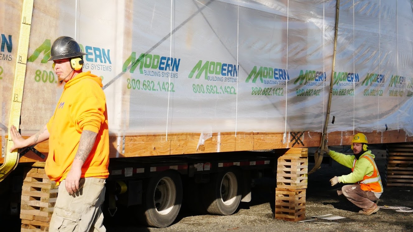 Construction crew delivering a building module.