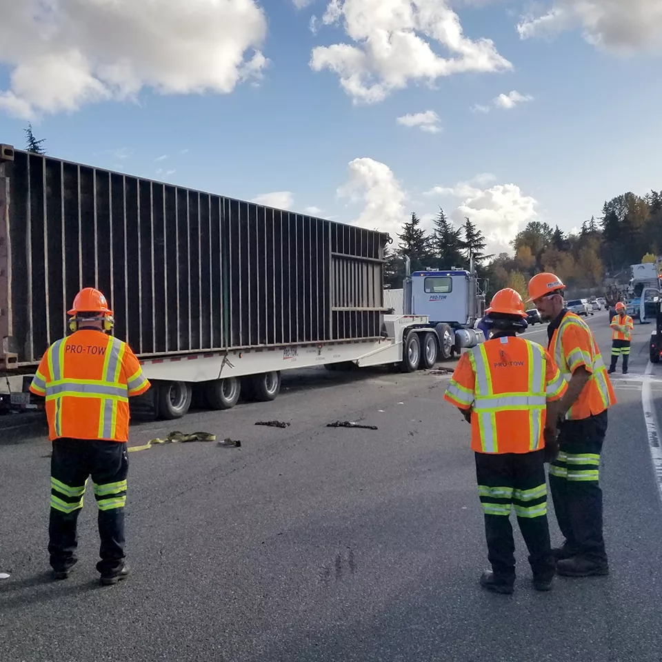 Towing and recovery team along roadway.